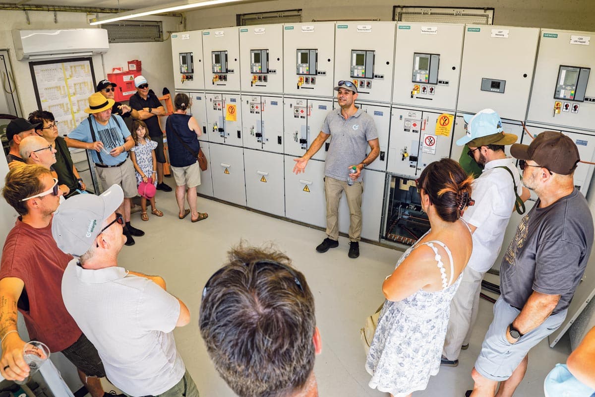 Ein Mitarbeiter erklärt die Schaltanlage des Grossbatteriespeichers.